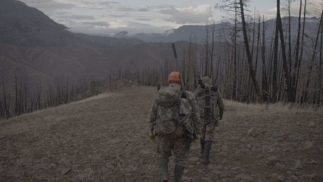 Hunters moving along a mountain ridge