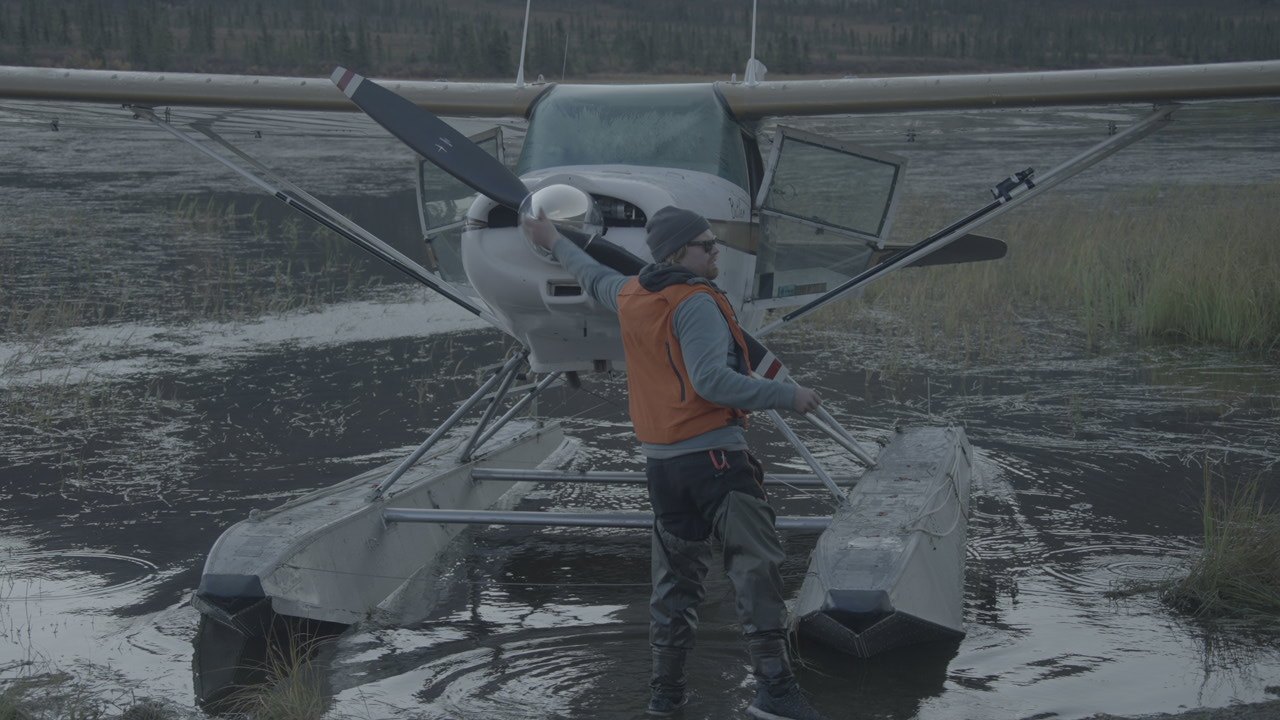 Loading a floatplane beside a lake